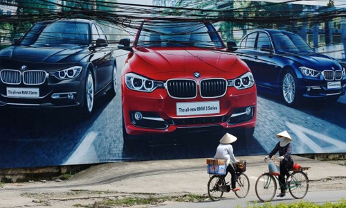 Bên cạnh chiếc Poster quảng cáo cho loại xe BMW đời mới là những chiếc xe đạp cũ kĩ trên đường phố 